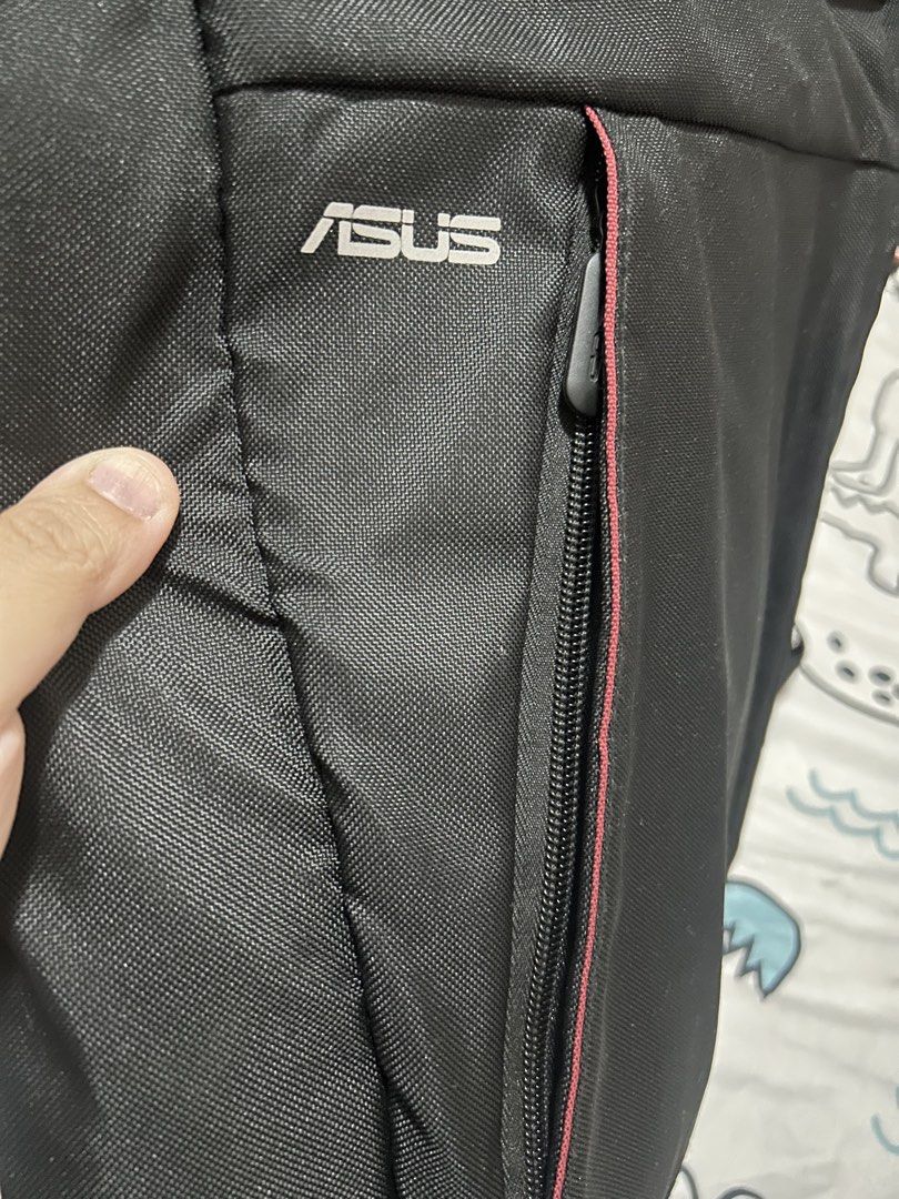 ASUS Black Laptop Backpack (Category: Backpacks) located in Paranaque City. Submitted by allthatclutterph (Listing ID 1442505553, Image 3). Description: - Stylish black ASUS backpack - Features a front zip pocket with eye-catching red trim - Adjustable straps for a comfortable fit - Multiple internal compartments for organized storage - Durable zippers with distinct ASUS branding - Ideal for carrying your laptop and daily essentials - Seldom used