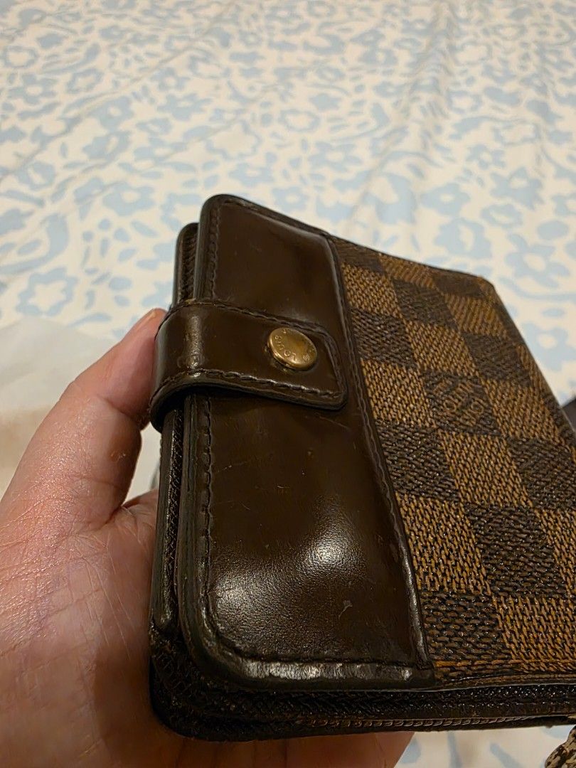 Authentic Louis Vuitton Damier Ebene Canvas Wallet (Category: Luxury Bags & Wallets) located in Taytay. Submitted by brightdog.huskies (Listing ID 1442474997, Image 3). Description: - Authentic Louis Vuitton wallet in Damier Ebene canvas. - Features a secure snap button closure. - Includes a convenient zipped coin compartment. - Interior boasts multiple card slots and bill compartments for organization. - Shows minor signs of wear on leather trim