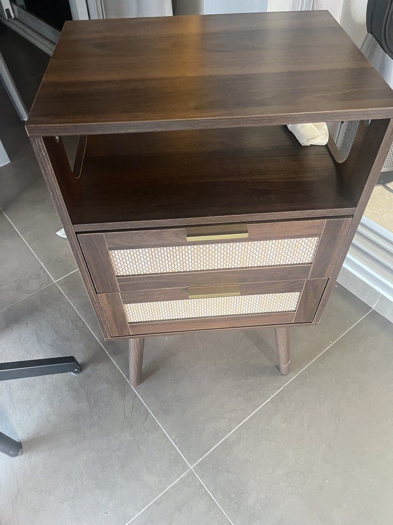 Bedside table (Category: Shelves, Cabinets & Racks) located in Singapore. Submitted by lialia28 (Listing ID 1442524510, Image 1). Description: Bedside table - dimensions 11.42”D x 15.35”W x 24.45”H Engineered wood Walnut brown. Embrace the farmhouse touch: A classic rattan faucet, this nightstand gives off a modern touch in your bedroom. With a row insert makes it more practical, the atmosphere lamp is a good addition to the fun of life, it can a