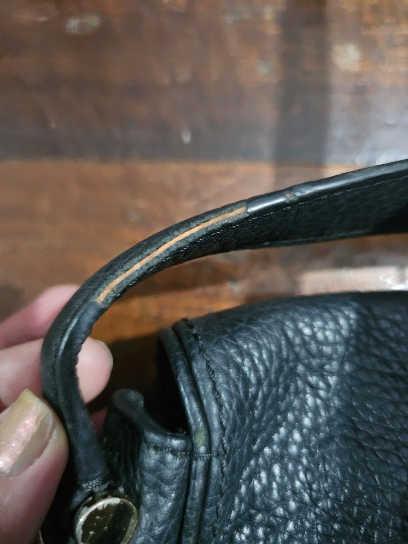 Black leather handbag strap with wear (Category: Shoulder Bags) located in Quezon City. Submitted by bingblings (Listing ID 1442417299, Image 3). Description: - Genuine black leather handbag strap - Features pebbled leather texture - Attached gold-tone hardware - Shows some signs of wear along the edge (scuffing, discoloration).