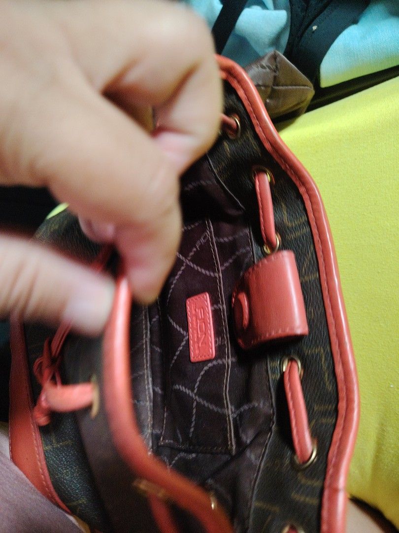 Brown Monogram Bucket Bag with Red Trim and Pouch (Category: Cross-body Bags) located in Taguig. Submitted by roxie0419 (Listing ID 1442344573, Image 3). Description: - Stylish brown bucket bag with repeating monogram pattern - Elegant red leather trim and drawstring details - Includes a small matching pouch for essentials - Detachable crossbody strap for versatile carrying - Polished gold hardware accents - Interior branded tag for authenticity 