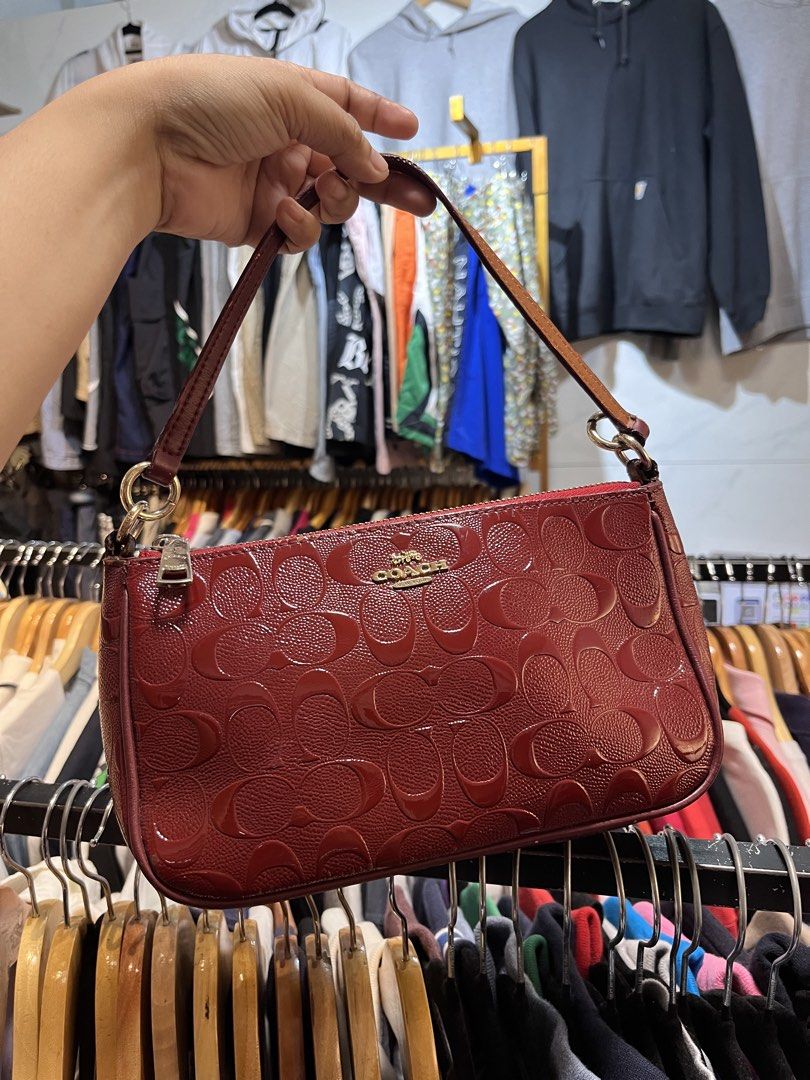 Coach Monogram Embossed Leather Shoulder Bag (Category: Luxury Bags & Wallets) located in Davao. Submitted by 4mscllection (Listing ID 1442405271, Image 1). Description: - Authentic Coach shoulder bag - Deep red color with all-over embossed monogram pattern - Gold hardware and zipper closure - Interior Coach creed tag and serial number - Small and compact, ideal for essentials - Versatile for night outs or casual use.