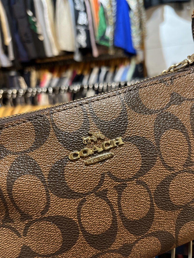Coach Monogram Pouch with Chain Strap (Category: Luxury Bags & Wallets) located in Davao. Submitted by 4mscllection (Listing ID 1442405604, Image 2). Description: - Authentic Coach monogram pouch - Features a chic gold chain strap - Secure zip closure - Signature Coach logo on front and zipper pull - Stylish orange trim detail - Ideal for carrying your daily essentials.