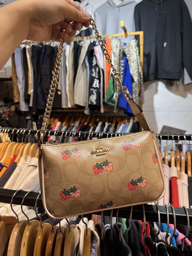 Coach Monogram Strawberry Print Mini Bag with Chain (Category: Luxury Bags & Wallets) located in Davao. Submitted by 4mscllection (Listing ID 1442405398, Image 1). Description: - Cute Coach mini bag - Classic monogram print with fun strawberry design - Gold chain strap - Zipper closure - Ideal for carrying essentials - Small and compact.