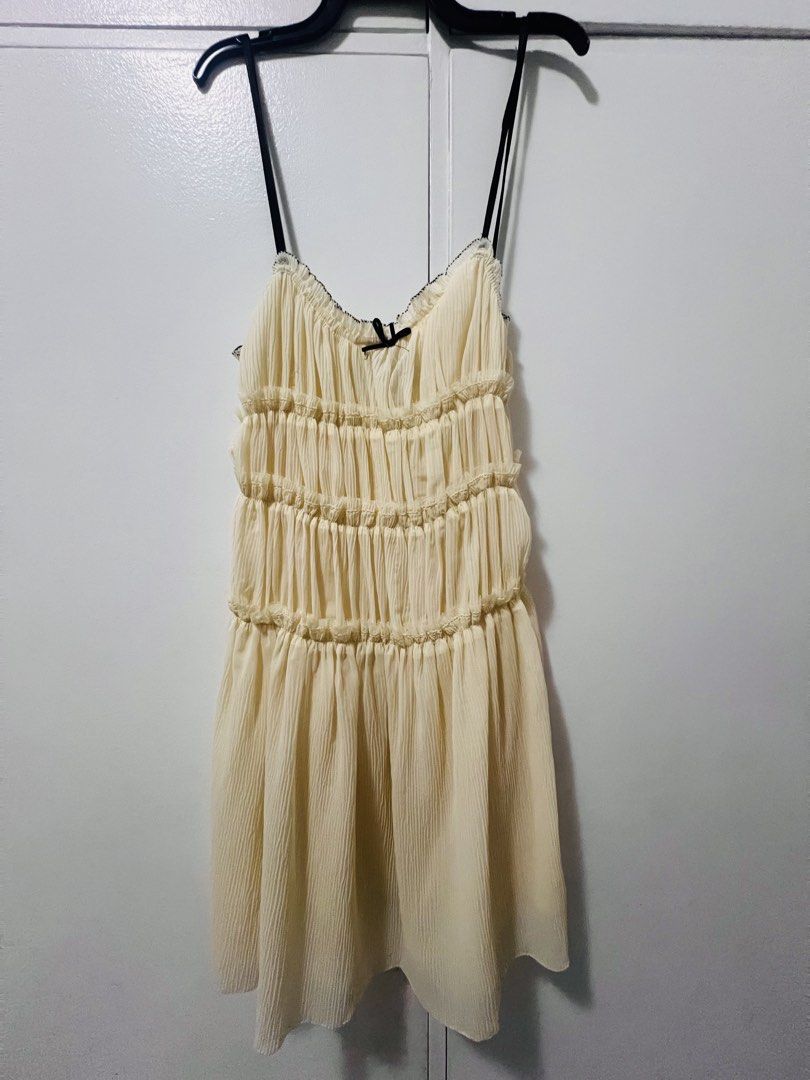 Cream Ruched Mini Dress with Black Straps (Category: Dresses) located in Makati City. Submitted by g.ang.s (Listing ID 1442474842, Image 2). Description: - Cream colored mini dress - Ruched detailing on bodice - Gathered waist - Thin black spaghetti straps with small black bow at bust - Lightweight and flowy fabric - Versatile for casual outings or nights out.