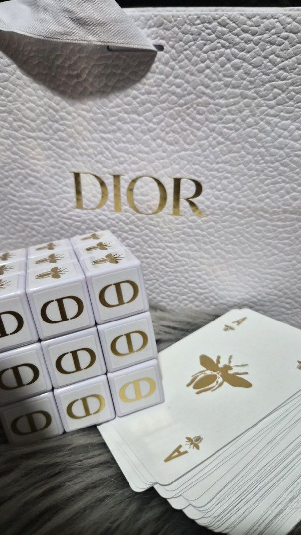 Dior Gold Gift - Playing Cards & Rubik's Cube Set (Category: Board Games & Puzzles) located in Antipolo. Submitted by patrishaenrique (Listing ID 1442468740, Image 1). Description: - Authentic Dior collector's set - Includes iconic bee motif playing cards - Features a CD logo Rubik's cube style puzzle - Both items are white with elegant gold accents - Comes with an original Dior shopping bag - Ideal for collectors or as a luxurious gift.