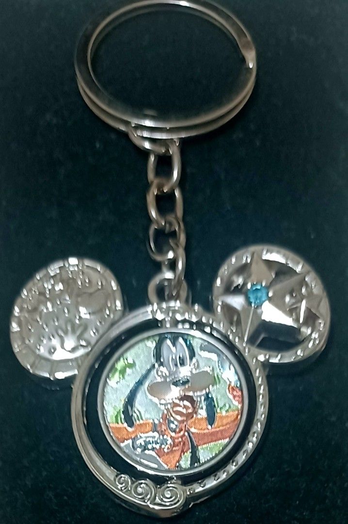 Disney Goofy Mickey Mouse Ears Keychain (Category: Character Goods) located in Quezon City. Submitted by wjmae (Listing ID 1442413236, Image 1). Description: - Features a fun Goofy design. - Mickey Mouse ears with unique details: one ear has a star and blue gem, the other has a raised pattern. - The center piece of the keychain spins. - Ideal for any Disney fan or collector. - Adds a touch of Disney magic to your keys..