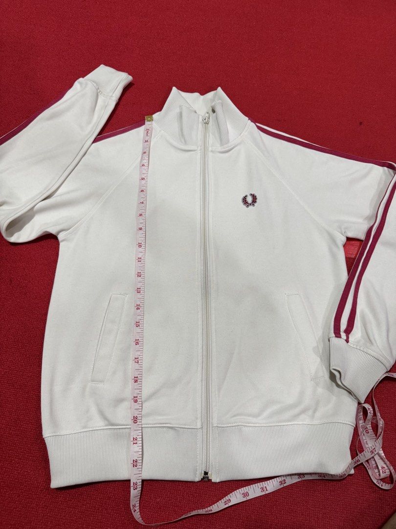 Fred Perry White Track Jacket with Burgundy Stripes (Category: Coats, Jackets and Outerwear) located in Manila. Submitted by pormaatbpshoppe (Listing ID 1442362428, Image 3). Description: - White Fred Perry track jacket - Iconic embroidered laurel wreath logo on chest - Burgundy stripes along sleeves and collar - Full zip closure - Two side pockets - Ribbed cuffs and hem.