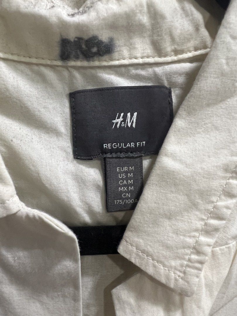 H&M Regular Fit Short Sleeve Shirt (Category: Tshirts & Polo Shirts ) located in Quezon City. Submitted by goodstuffsssssph (Listing ID 1442386272, Image 2). Description: - Cream colored short sleeve button-up shirt - Brand: H&M - Fit: Regular - Features: Chest pocket - Condition: Minor faint marks on collar area (please check photos for details).