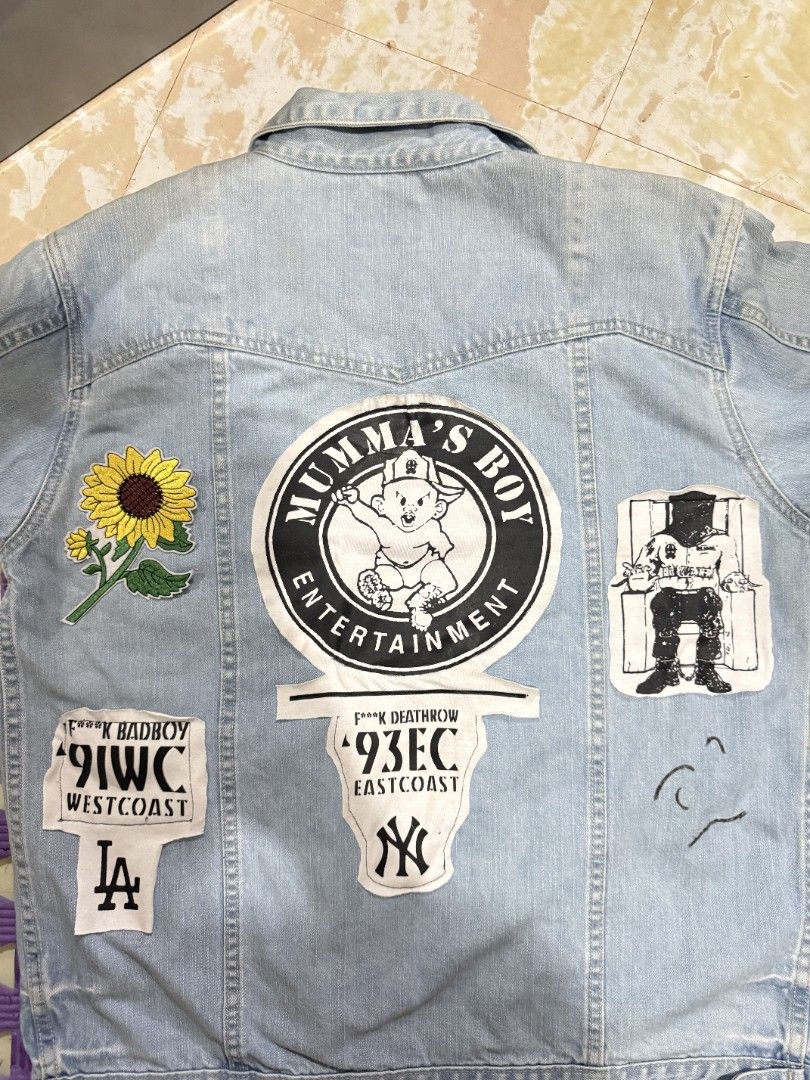 JAG Authentic Classic Denim Jacket with Patches Size L (Category: Coats, Jackets and Outerwear) located in Manila. Submitted by its.thrifted (Listing ID 1442526166, Image 2). Description: - JAG light wash denim jacket - Size: Large (L) - Unique custom patches on the back: 'MUMMA'S BOY ENTERTAINMENT', New York Yankees, Los Angeles Dodgers, sunflower, and more graphics. - Classic button-up front - Two chest pockets - Perfect statement piece to elev