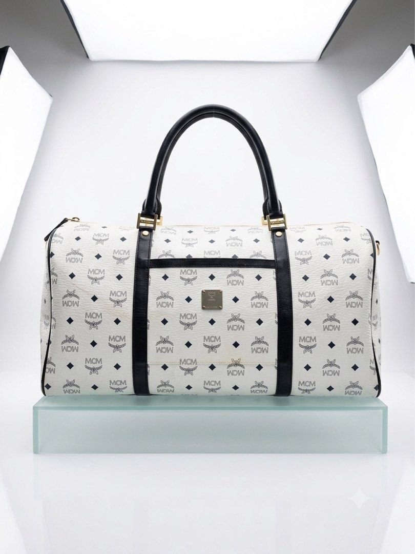 MCM Monogram Duffel Bag (Category: Luxury Bags & Wallets) located in Davao. Submitted by brobewerty40648 (Listing ID 1442381811, Image 1). Description: - Rare MeCM White Visetos Boston Duffel Travel Bag - Classic MCM duffel bag - Signature white monogram print - Black leather trim and handles - Gold hardware details - Spacious interior - Ideal for travel or everyday use - A timeless piece.