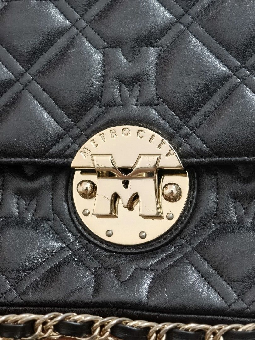 METROCITY Black Quilted Leather Chain Shoulder Bag (Category: Shoulder Bags) located in Manila. Submitted by bmsthrift (Listing ID 1442452410, Image 2). Description: - Brand: METROCITY - Material: Black quilted leather - Strap: Gold chain shoulder strap - Closure: Zipper - Details: Signature 'M' logo on front closure and interior tag - Style: Versatile for everyday use or evening events.