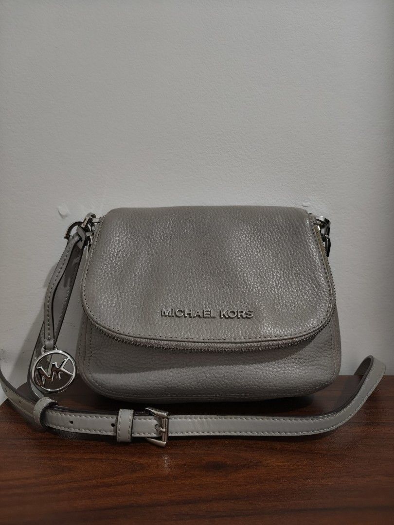Michael Kors Grey Leather Crossbody Bag (Category: Cross-body Bags) located in Manila. Submitted by bmsthrift (Listing ID 1442452160, Image 1). Description: - Authentic Michael Kors grey leather crossbody bag - Features iconic MK logo charm - Elegant silver hardware - Secure front pocket with zipper closure - Adjustable strap for personalized comfort - Spacious interior for all your daily essentials - Ideal for everyday use.