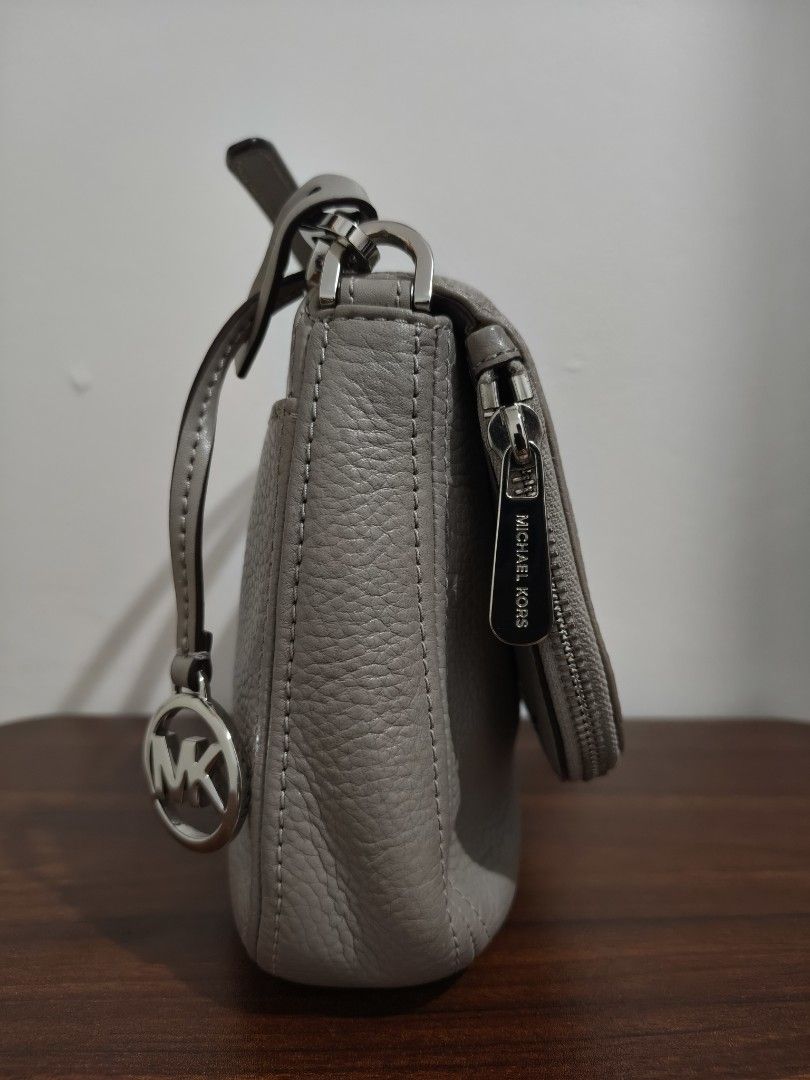 Michael Kors Grey Leather Crossbody Bag (Category: Cross-body Bags) located in Manila. Submitted by bmsthrift (Listing ID 1442452160, Image 3). Description: - Authentic Michael Kors grey leather crossbody bag - Features iconic MK logo charm - Elegant silver hardware - Secure front pocket with zipper closure - Adjustable strap for personalized comfort - Spacious interior for all your daily essentials - Ideal for everyday use.