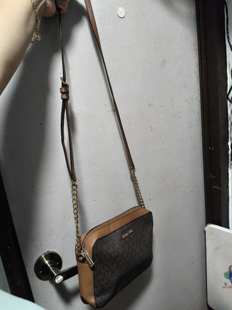 Michael Kors Monogram Crossbody Bag with Chain Strap (Category: Cross-body Bags) located in Manila. Submitted by stuff_finder (Listing ID 1442480983, Image 2). Description: - Authentic Michael Kors crossbody bag - Classic MK monogram print - Tan leather trim and accents - Gold chain and leather strap - Two zippered compartments for secure storage - Versatile for everyday wear or evening events.