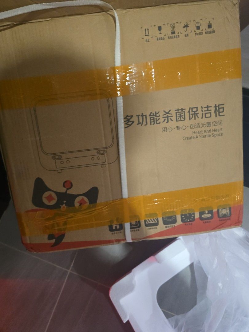 Multi-function Sterilizer Box (Category: Breastfeeding & Bottle Feeding) located in Singapore. Submitted by xscape84bear (Listing ID 1442519070, Image 2). Description: Multi-function sterilizer box with transparent window and side controls. Brown exterior with graphics. Item inside is black and white..
