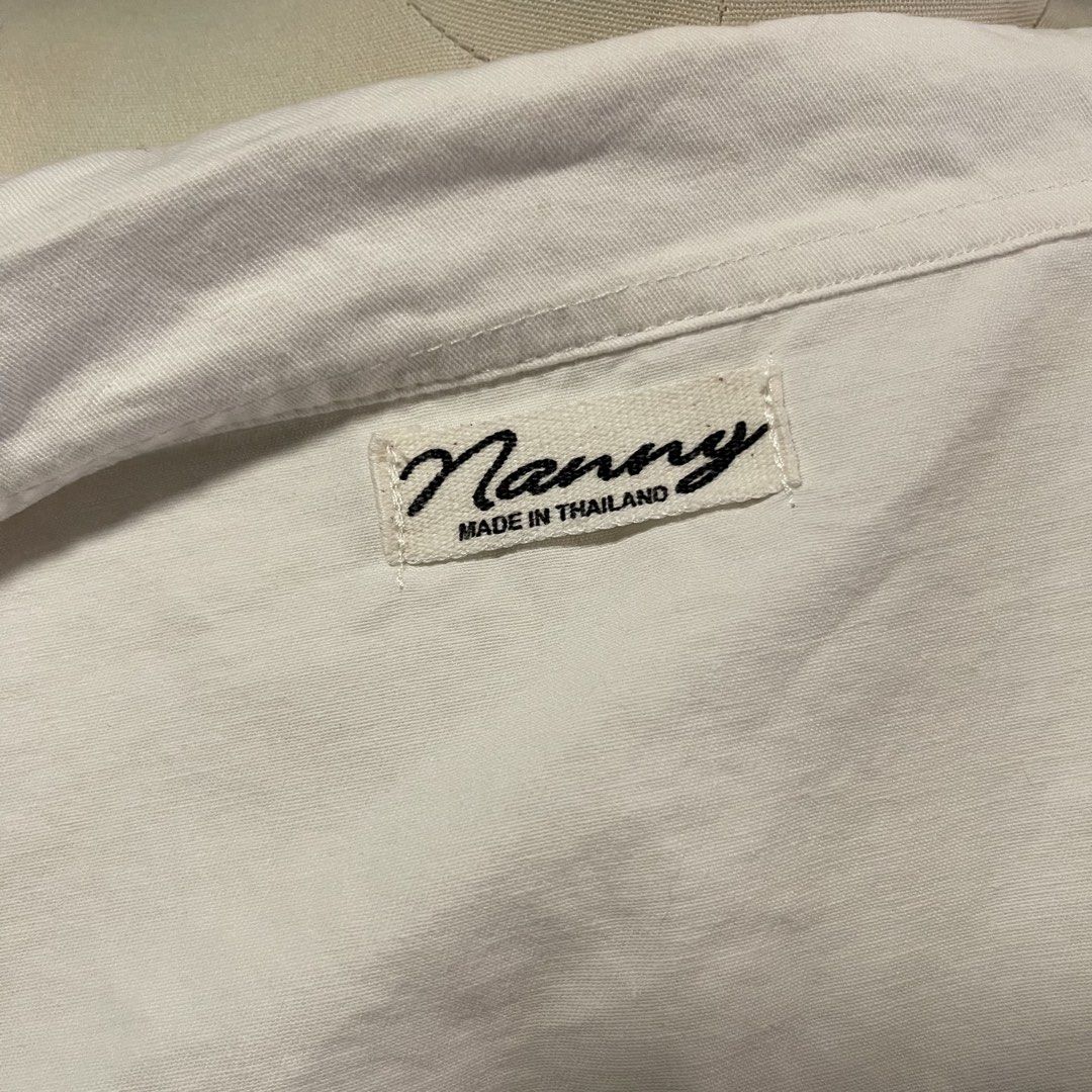 Nanny White Cropped Button-Up Shirt with Pockets (Category: Shirts) located in General Trias. Submitted by 1992thelabel (Listing ID 1442466647, Image 3). Description: - White cropped shirt from Nanny - Short sleeves - Collared neckline - Two chest pockets with button closures - Button-up front - Made in Thailand - Versatile piece, pairs well with high-waisted bottoms.