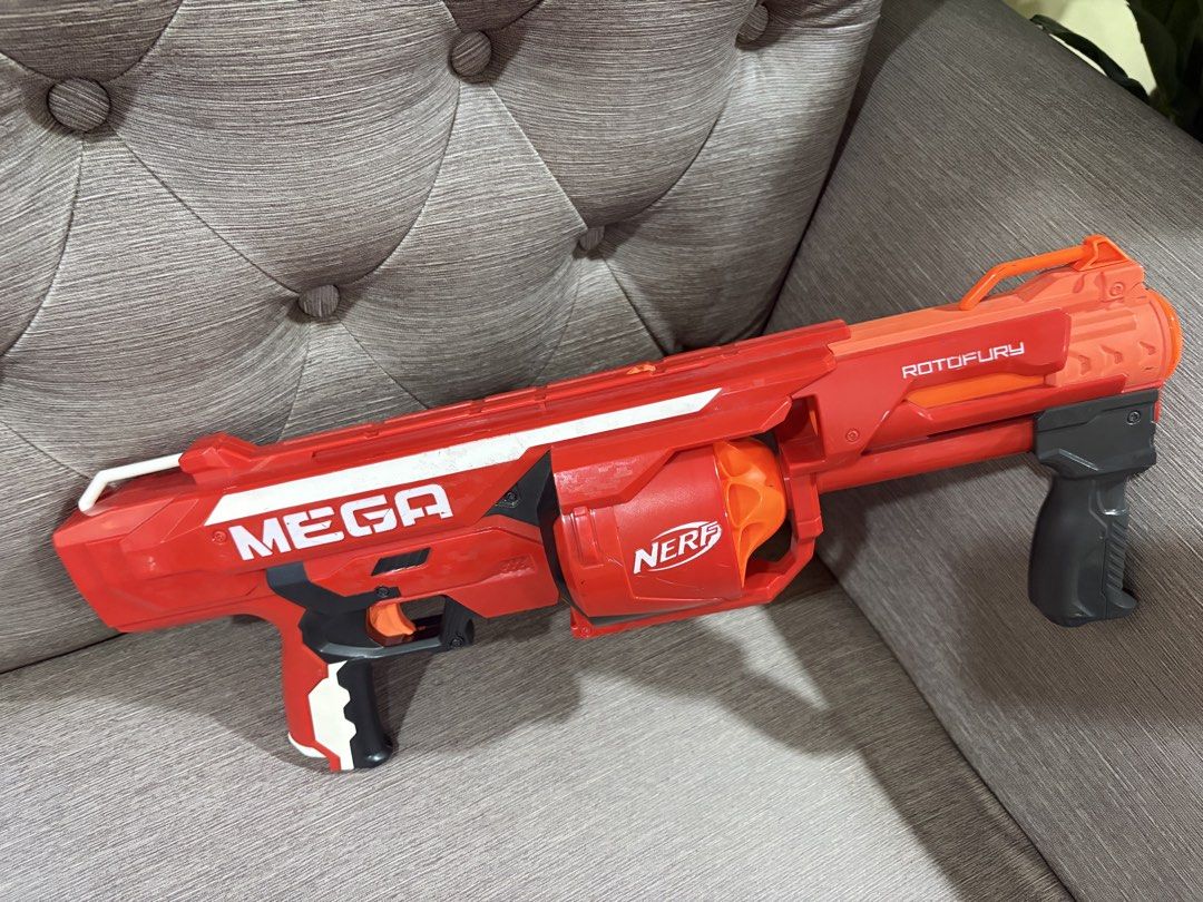 Nerf Mega Rotofury Blaster Toy Gun (Category: Action & Battle Toys) located in Manila. Submitted by dig76 (Listing ID 1442421580, Image 2). Description: - Red Nerf Mega Rotofury blaster - Features a rotating drum for multiple darts - Red with white and grey accents - Nerf logo visible on the drum - Ideal for outdoor play and target practice - A fun toy for Nerf enthusiasts.