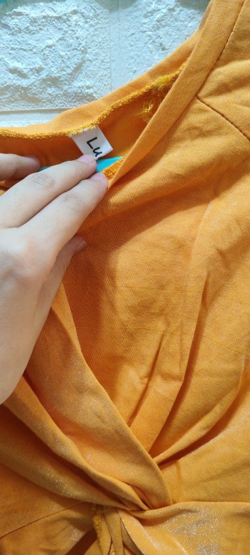 Orange Twisted Front Crop Top (Category: Others Tops) located in Rizal. Submitted by annmaria_declutter (Listing ID 1442431793, Image 3). Description: - Trendy orange crop top - Unique twisted front detail - Comfortable, soft fabric - Versatile for casual or dressed-up outfits - Pairs well with high-waisted jeans and skirts - Easy to style for a chic look -orange top na medyo shiny .