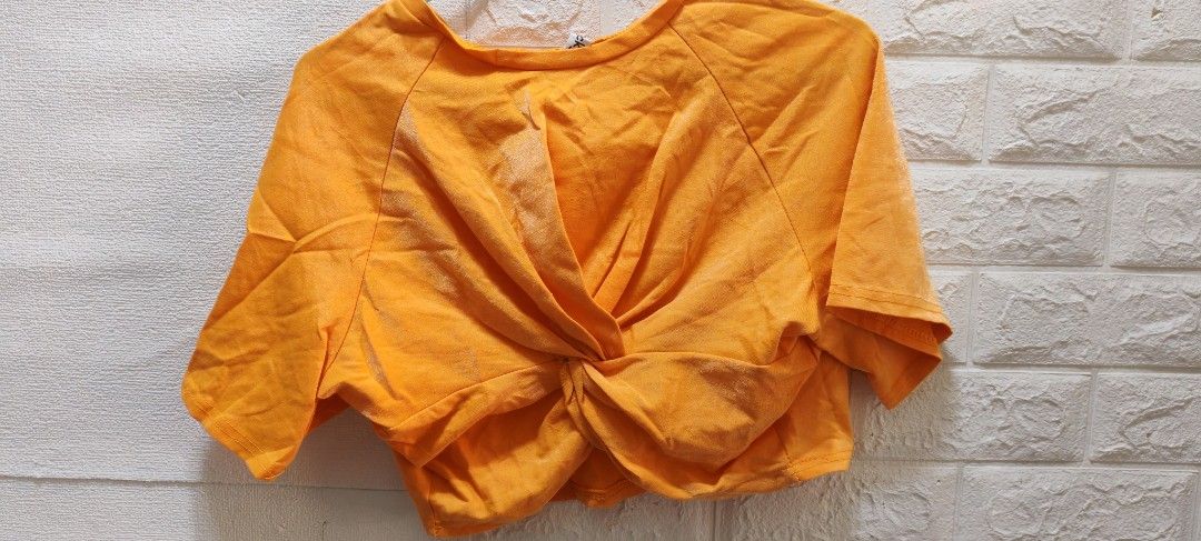 Orange Twisted Front Crop Top (Category: Others Tops) located in Rizal. Submitted by annmaria_declutter (Listing ID 1442431793, Image 1). Description: - Trendy orange crop top - Unique twisted front detail - Comfortable, soft fabric - Versatile for casual or dressed-up outfits - Pairs well with high-waisted jeans and skirts - Easy to style for a chic look -orange top na medyo shiny .