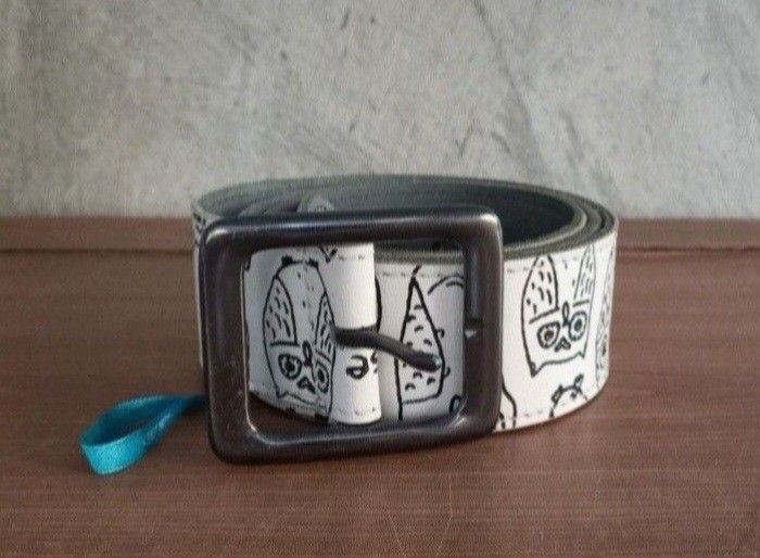 SALAD OWL WHITE PRINTED LEATHER BELT (Category: Activewear) located in Lamut. Submitted by sakosack (Listing ID 1442376871, Image 1). Description: Unique belt featuring an owl print design. The belt has a square buckle and a blue tag. The brand name "Salad" is visible on the belt. The belt's interior is a dark grey color. The belt has a "birds paradise" tag..