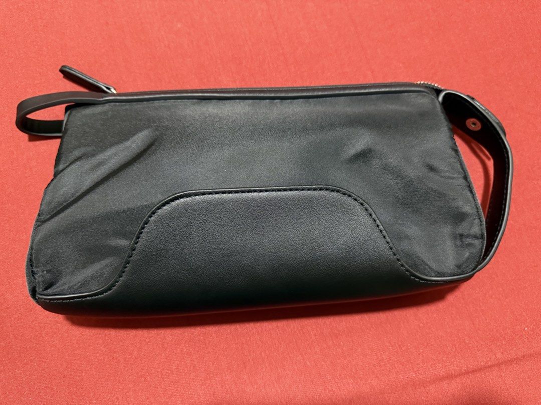 Shigetsu Black Clutch Bag (Category: Clutches) located in Manila. Submitted by flicker_33 (Listing ID 1442504864, Image 2). Description: - Sleek black clutch bag - Elegant silver logo on the front - Secure zip closure - Convenient wrist strap - Interior zippered pocket - Interior slip pocket - Ideal for carrying your daily essentials.