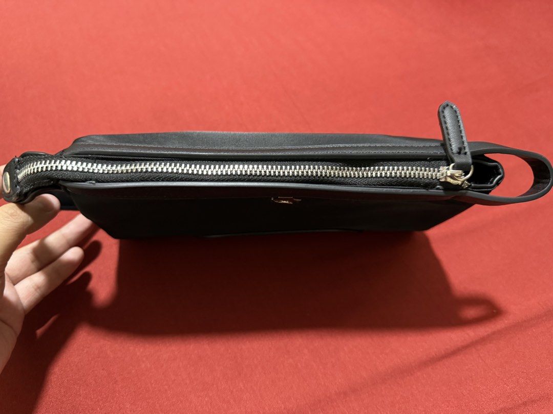 Shigetsu Black Clutch Bag (Category: Clutches) located in Manila. Submitted by flicker_33 (Listing ID 1442504864, Image 3). Description: - Sleek black clutch bag - Elegant silver logo on the front - Secure zip closure - Convenient wrist strap - Interior zippered pocket - Interior slip pocket - Ideal for carrying your daily essentials.