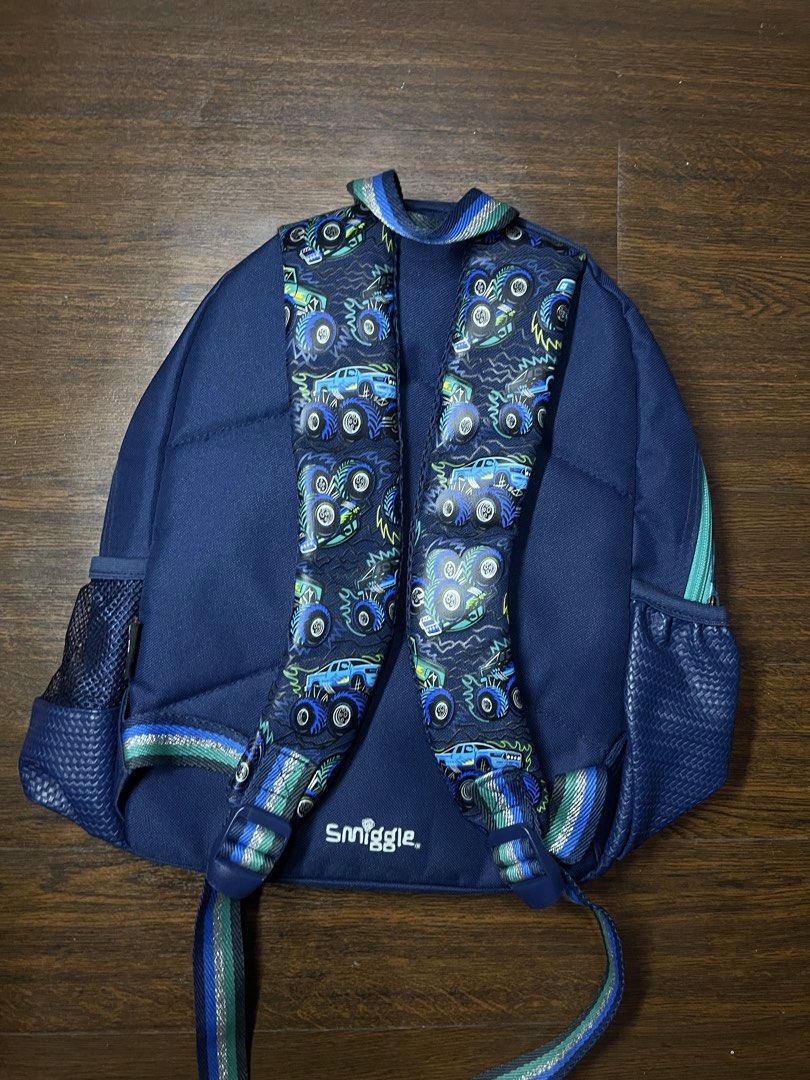 Smiggle Junior Backpack (Category: Babies & Kids Fashion) located in Calamba. Submitted by vlsnts (Listing ID 1442448247, Image 2). Description: - Fun monster truck design - Navy blue with teal accents - Side mesh pockets for drinks - Adjustable padded shoulder straps - Internal name tag label - Ideal for school or day trips.