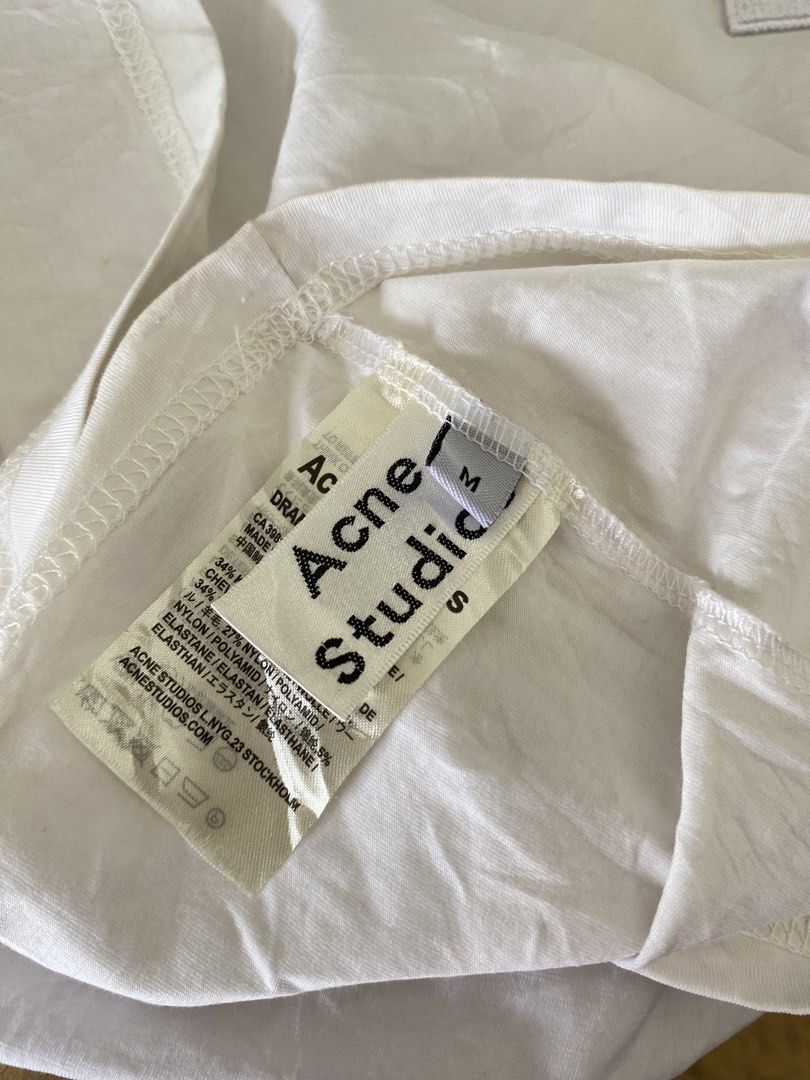 This white Acne Studios T-shirt features the signature tonal embroidered face logo patch on the chest (Category: Tshirts & Polo Shirts ) located in Manila. Submitted by luxbyjyy (Listing ID 1442484847, Image 3). Description: This white Acne Studios T-shirt features the signature tonal embroidered face logo patch on the chest Dimension:W20 L27.