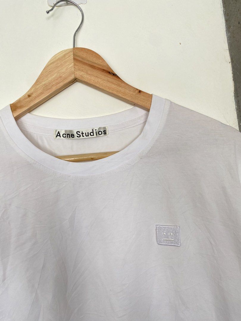 This white Acne Studios T-shirt features the signature tonal embroidered face logo patch on the chest (Category: Tshirts & Polo Shirts ) located in Manila. Submitted by luxbyjyy (Listing ID 1442484847, Image 2). Description: This white Acne Studios T-shirt features the signature tonal embroidered face logo patch on the chest Dimension:W20 L27.