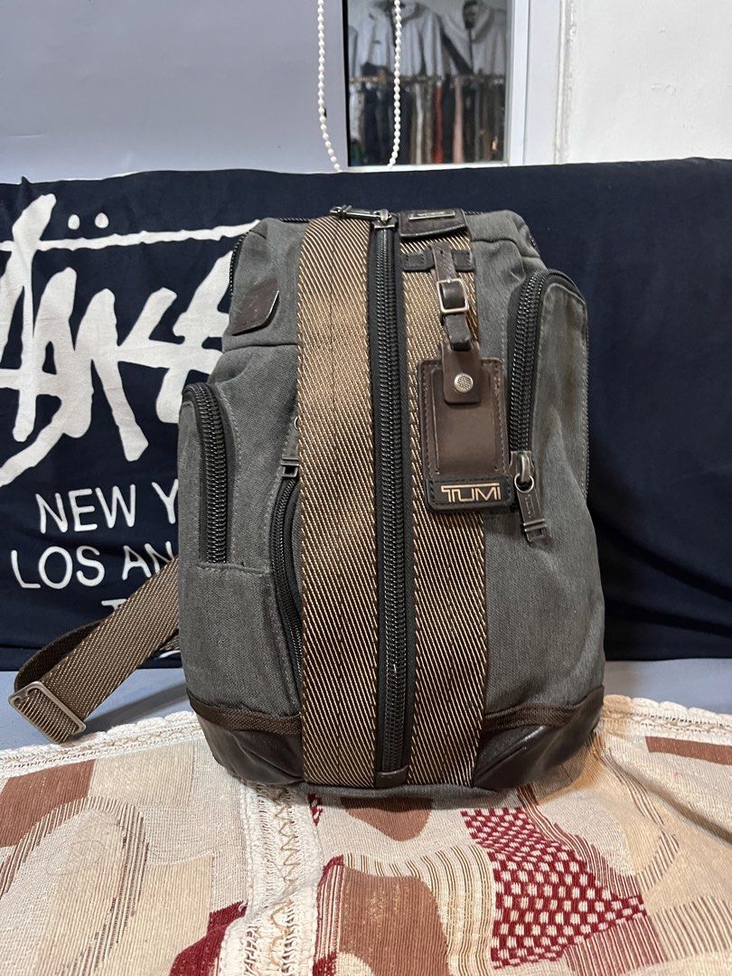 Tumi Sling Bag Grey Canvas Leather Trim (Category: Belt bags, Clutches and Pouches) located in Davao. Submitted by 4mscllection (Listing ID 1442404508, Image 1). Description: - Grey Tumi sling bag - Durable canvas and leather details - Multiple zippered compartments for organization - Adjustable strap for comfortable wear - Perfect for everyday use.
