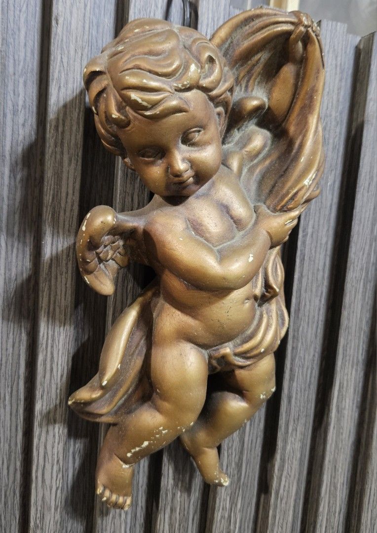 Vintage Gold Cherub Angel Wall Hanging Decor (Category: Wall Decor) located in Rizal. Submitted by cherry_garcia (Listing ID 1442421621, Image 3). Description: - Adorable cherub angel wall hanging - Elegant gold-tone finish - Stands approximately 9 inches tall - Features minor paint chips, consistent with vintage charm - Adds a touch of vintage charm to any space - Ideal for nurseries, living rooms, or any room needing a sweet accent.