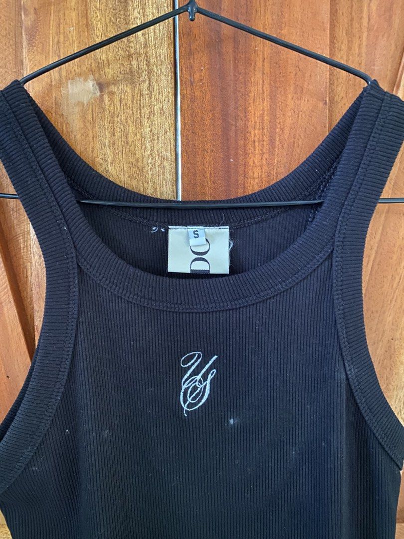 Undo Black Ribbed Tank Top (Category: Sleeveless) located in Pasig City. Submitted by tlm0317 (Listing ID 1442670948, Image 3). Description: - Small embroidered logo on front - Racerback style - Condition: well loved, has white stains; unsure if can be removed RFS: Decluttering.