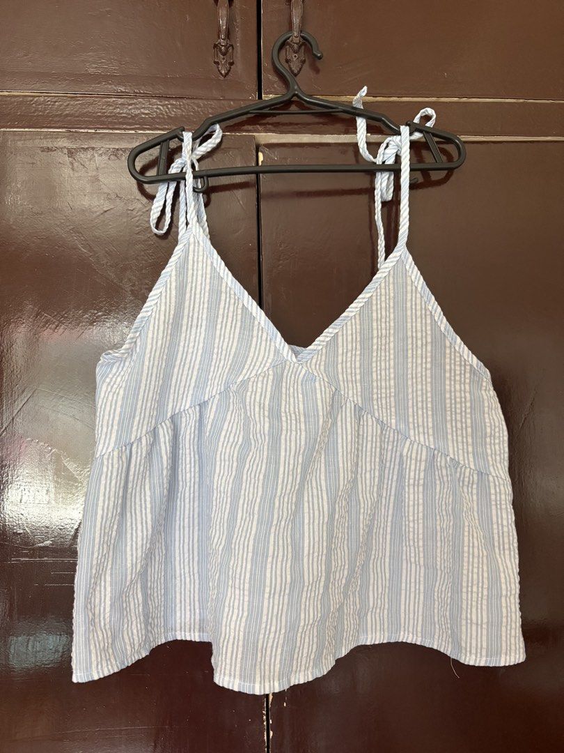Blue and White Striped Tie-Strap Summer Top (Category: Sleeveless) located in Manila. Submitted by secondsbyem (Listing ID 1442594460, Image 1). Description: - Cute blue and white striped peplum top - Adjustable tie straps on shoulders - Flattering V-neckline - Empire waist design - Lightweight fabric, ideal for warm weather - Versatile: pairs well with shorts or jeans - Perfect for casual outings and beach days.