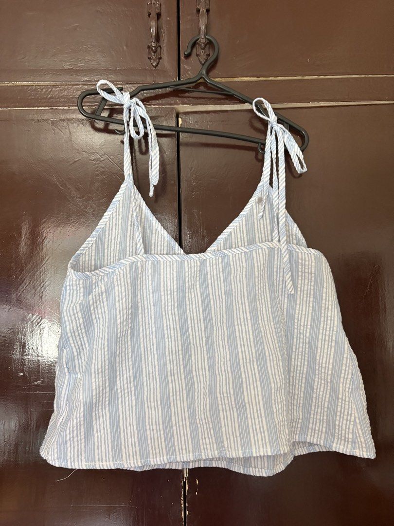 Blue and White Striped Tie-Strap Summer Top (Category: Sleeveless) located in Manila. Submitted by secondsbyem (Listing ID 1442594460, Image 3). Description: - Cute blue and white striped peplum top - Adjustable tie straps on shoulders - Flattering V-neckline - Empire waist design - Lightweight fabric, ideal for warm weather - Versatile: pairs well with shorts or jeans - Perfect for casual outings and beach days.