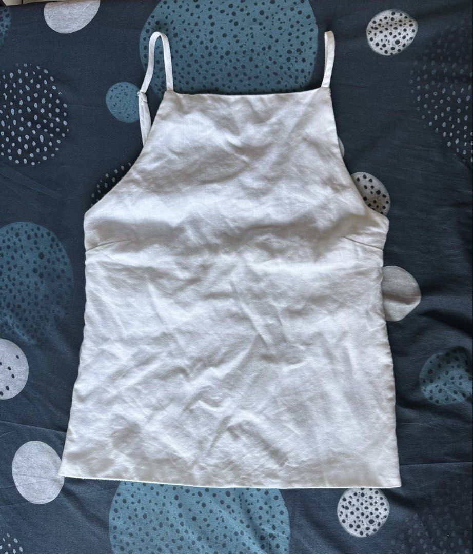 Carino Ingrid White Linen Top (Category: Sleeveless) located in Makati City. Submitted by bibas.corner (Listing ID 1442706801, Image 3). Description: - Chic white linen tank top - Elegant square neckline with thin spaghetti straps - Stylish open back detail - Convenient side zippers at the hem - Relaxed fit for comfortable wear.