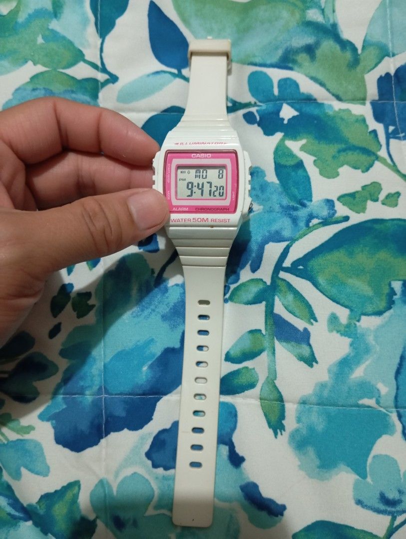 Casio Digital Watch W-215H White Pink (Category: Women's Watches) located in Muntinlupa City. Submitted by thriftsmuntinlupa26 (Listing ID 1442680465, Image 1). Description: - White Casio digital watch - Pink bezel - Alarm function - Chronograph function - Water resistant up to 50 meters - Strap has signs of wear - Battery is working - Ideal for everyday use.