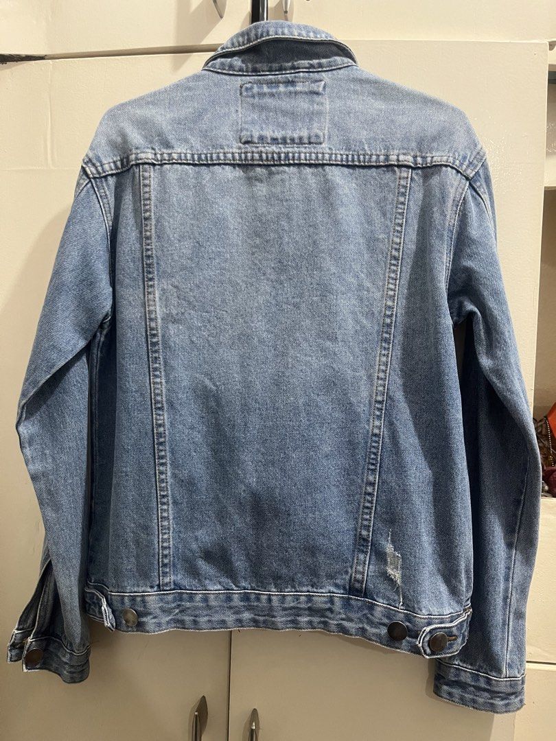 Cotton On Blue Denim Jacket Distressed Details (Category: Coats, Jackets and Outerwear) located in Cagayan de Oro. Submitted by everythingpreloved__ (Listing ID 1442685893, Image 2). Description: - Classic blue denim jacket from Cotton On - Distressed look with rips on front and back - Button-up closure - Two chest pockets - Buttoned cuffs - Ideal for casual layering and styling.