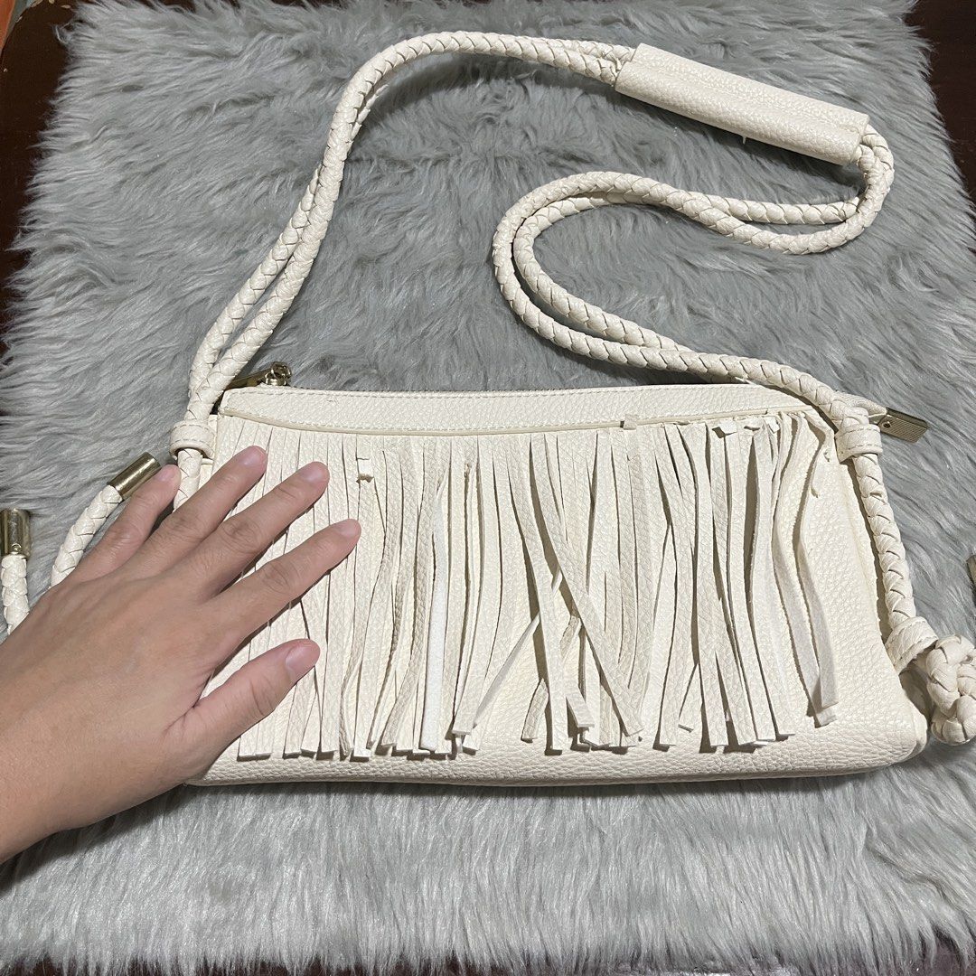 Fringed Sling Bag with Braided Strap (Category: Cross-body Bags) located in Manila. Submitted by declutterfairy_ph (Listing ID 1442676960, Image 2). Description: -Length: 11 inches (approx.) -Height: 6 inches (approx.) -Width: 1.5 inches (approx.) -Used once only; clean inside. -Kept for a while thus the flaws. -Flaws: some parts are peeled/peeling (synthetic leather) -This is unbranded, just bought from local stores. .