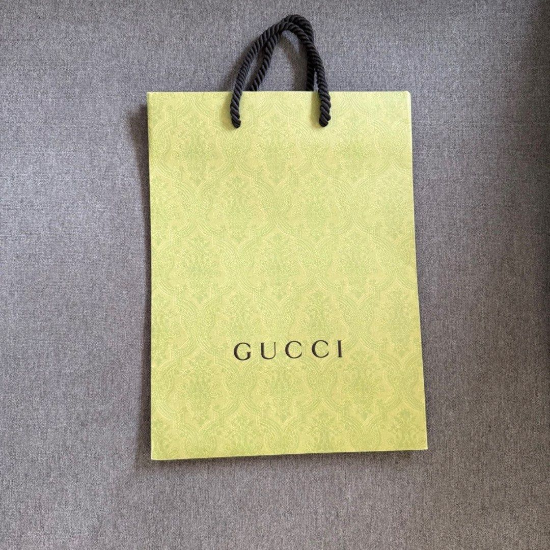 Gucci Shopping Bag (Category: Luxury Bags & Wallets) located in Quezon City. Submitted by tat.ph.12 (Listing ID 1442639394, Image 1). Description: - Authentic Gucci paper shopping bag - Light green color with subtle pattern - Features black Gucci logo - Black rope handles - Ideal for carrying purchases or decorative storage.