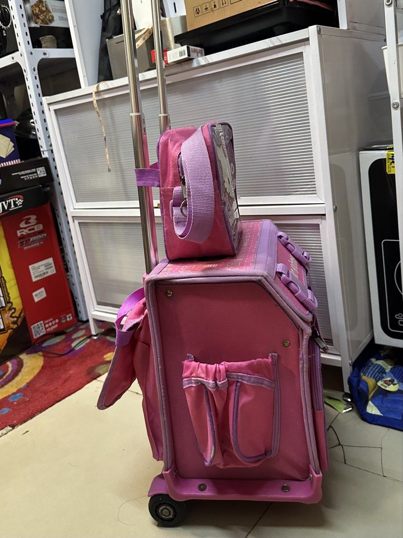Hello Kitty Pink Rolling Backpack with Matching Lunch Bag (Category: Backpacks) located in Quezon City. Submitted by mgracee (Listing ID 1442576821, Image 2). Description: - Adorable Kitty rolling backpack set in pink with purple accents. - Includes a large main backpack and a smaller matching lunch bag. - Features sturdy wheels and an extendable handle for effortless transport. - Ideal for school, day trips, or travel adventures. - Fun Kitty gra