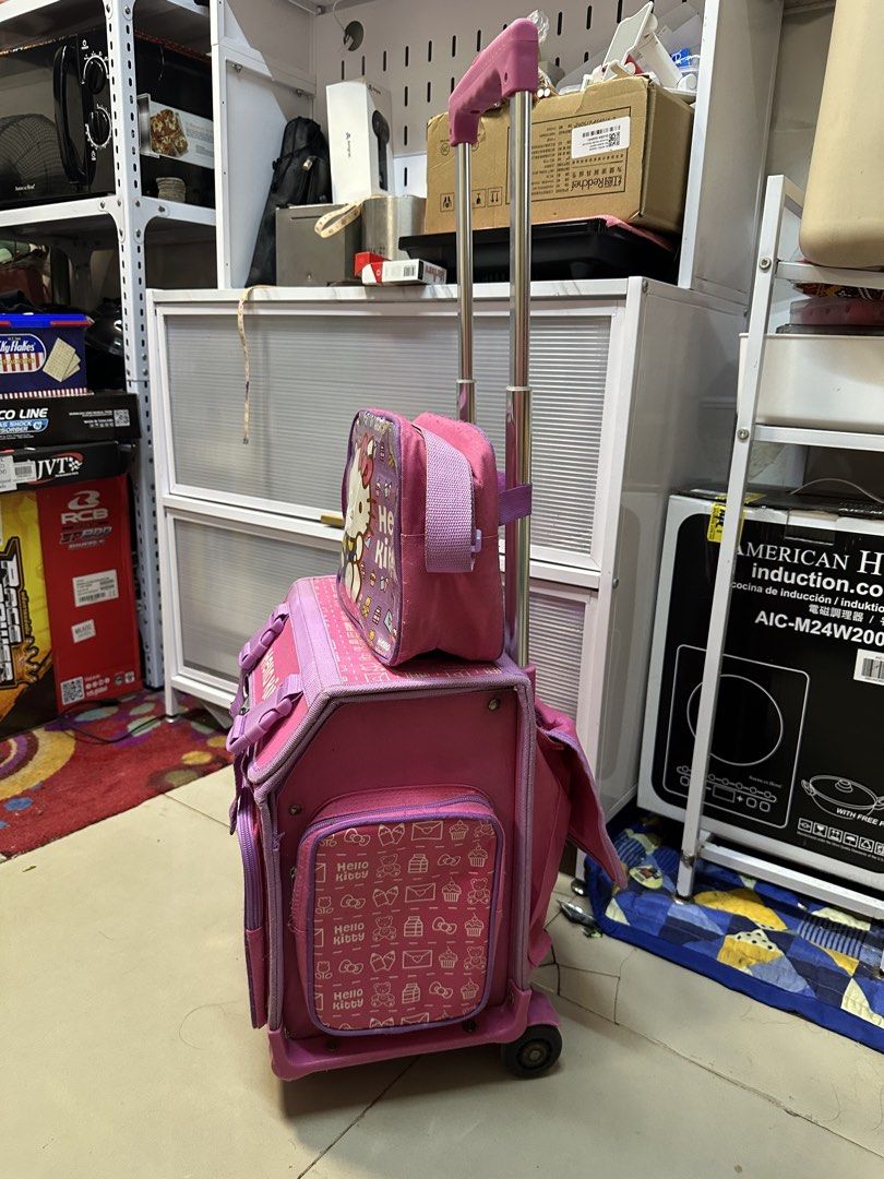 Hello Kitty Pink Rolling Backpack with Matching Lunch Bag (Category: Backpacks) located in Quezon City. Submitted by mgracee (Listing ID 1442576821, Image 3). Description: - Adorable Kitty rolling backpack set in pink with purple accents. - Includes a large main backpack and a smaller matching lunch bag. - Features sturdy wheels and an extendable handle for effortless transport. - Ideal for school, day trips, or travel adventures. - Fun Kitty gra