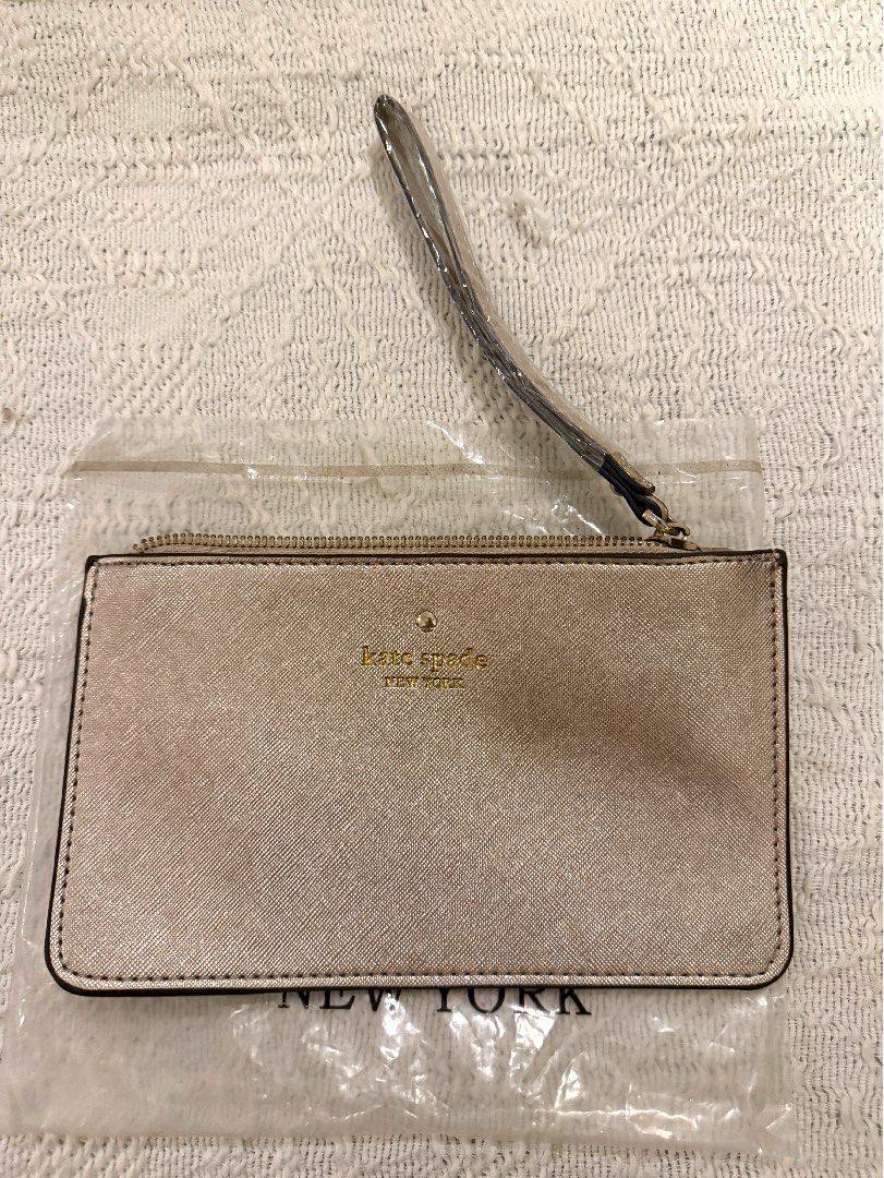 Kate Spade New York Wristlet Pouch (Category: Purses & Pouches) located in Paranaque City. Submitted by izdeclutters (Listing ID 1442656423, Image 1). Description: - Brand: Kate Spade New York - Color: Metallic Champagne - Closure: Zip - Features: Detachable wrist strap .