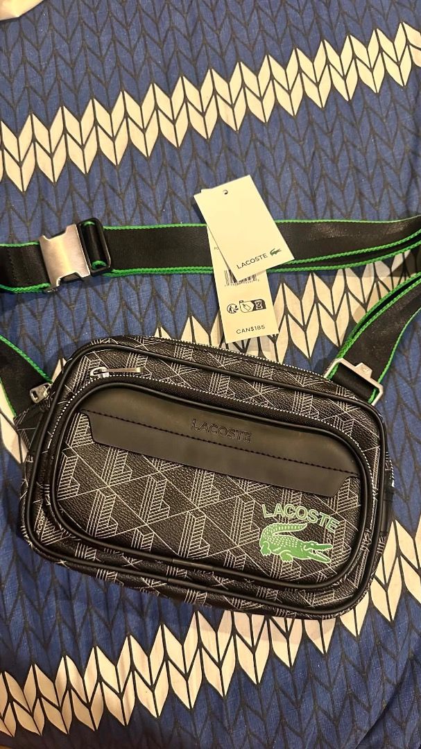 Lacoste Monogram Crossbody Bag Black Green Strap (Category: Cross-body Bags) located in Caloocan City. Submitted by krisellean89709 (Listing ID 1442556000, Image 2). Description: - Authentic Lacoste crossbody bag - Color: Black with white geometric monogram print - Adjustable strap with green trim and silver buckle - Multiple zippered compartments for organization - Ideal for everyday use or travel - Brand new with tags.