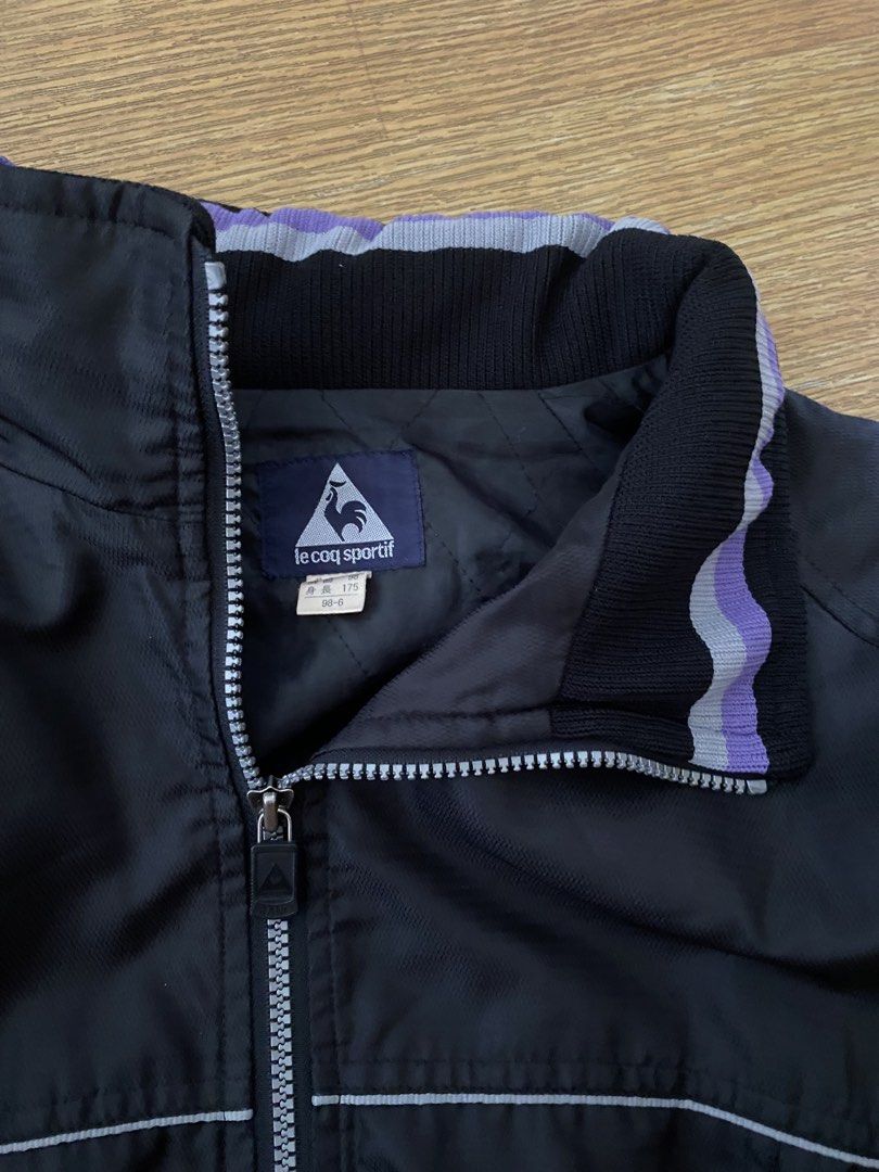 Le Coq Sportif Black Track Jacket (Category: Coats, Jackets and Outerwear) located in Manila. Submitted by deliriously (Listing ID 1442581066, Image 3). Description: - Black Le Coq Sportif track jacket - Features purple and grey striped collar and cuffs - Le Coq Sportif logo on sleeve and back - Zip-up front closure - May pocketable hood - 26.5 Length 25 Width Boxy type.