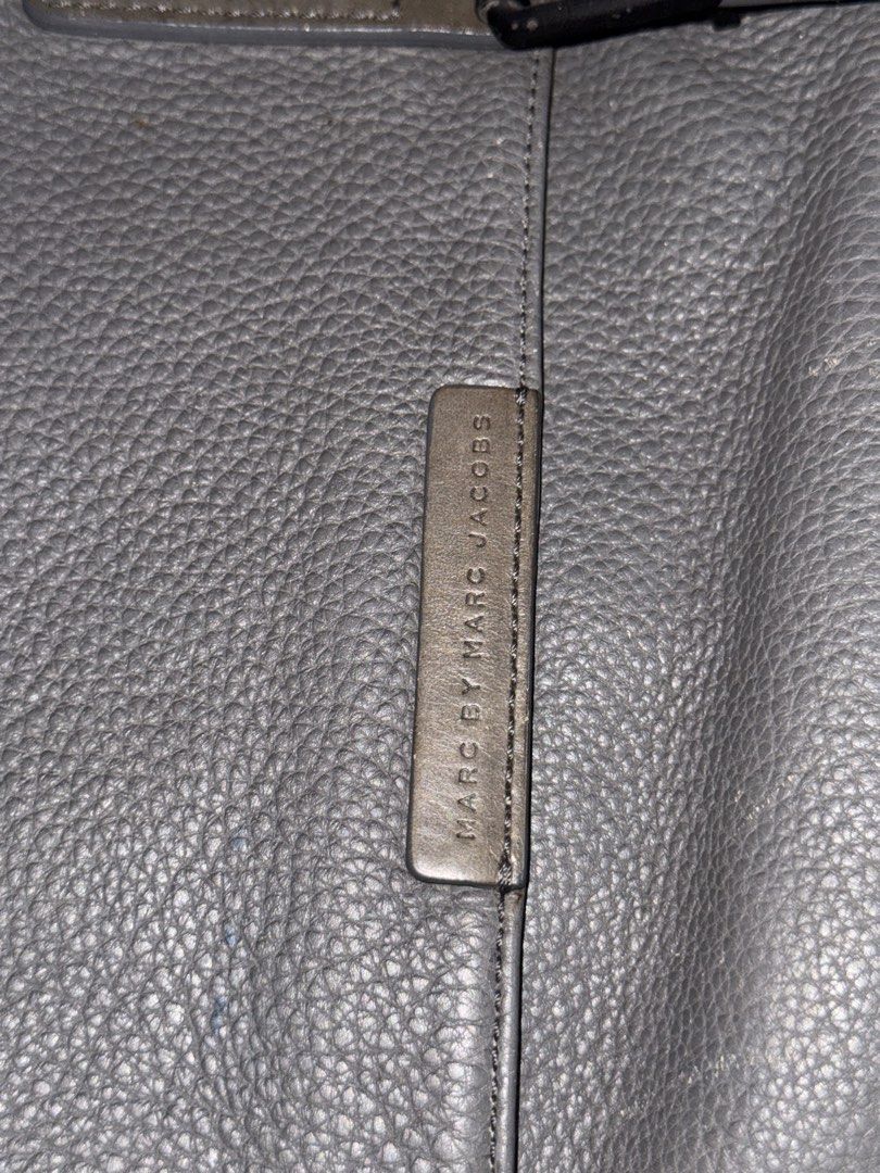 Marc by Marc Jacobs Grey Leather Messenger Bag (Category: Luxury Bags & Wallets) located in Makati City. Submitted by vinsanity41546 (Listing ID 1442605114, Image 2). Description: - Brand: Marc by Marc Jacobs - Material: Grey pebbled leather - Closure: Buckle closures on front flap - Strap: Adjustable shoulder strap - Interior: Zip pocket - Condition: Minor signs of wear on leather and strap - Ideal for: Everyday use.