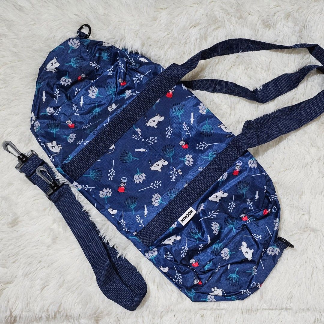 Moomin Navy Blue Duffel Bag with Cute Print (Category: Cross-body Bags) located in Taguig. Submitted by ljdm_22 (Listing ID 1442588941, Image 1). Description: - Navy blue duffel bag with fun Moomin print - Features white and red floral and character designs - Two top handles - Detachable shoulder strap with clip - Main compartment with zip closure - Ideal for travel or gym use location : Taguig City mode of payment : Gcash price negotiable .