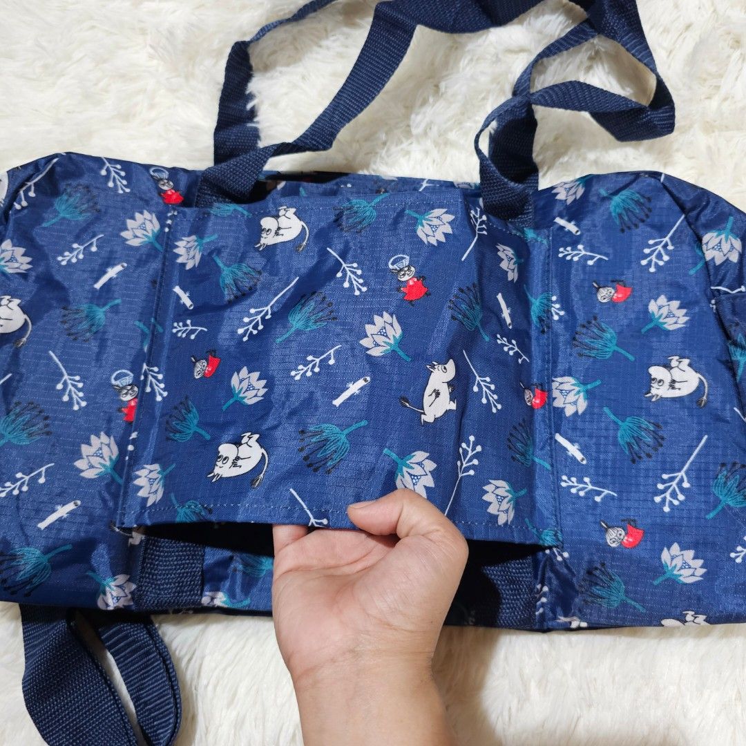 Moomin Navy Blue Duffel Bag with Cute Print (Category: Cross-body Bags) located in Taguig. Submitted by ljdm_22 (Listing ID 1442588941, Image 3). Description: - Navy blue duffel bag with fun Moomin print - Features white and red floral and character designs - Two top handles - Detachable shoulder strap with clip - Main compartment with zip closure - Ideal for travel or gym use location : Taguig City mode of payment : Gcash price negotiable .