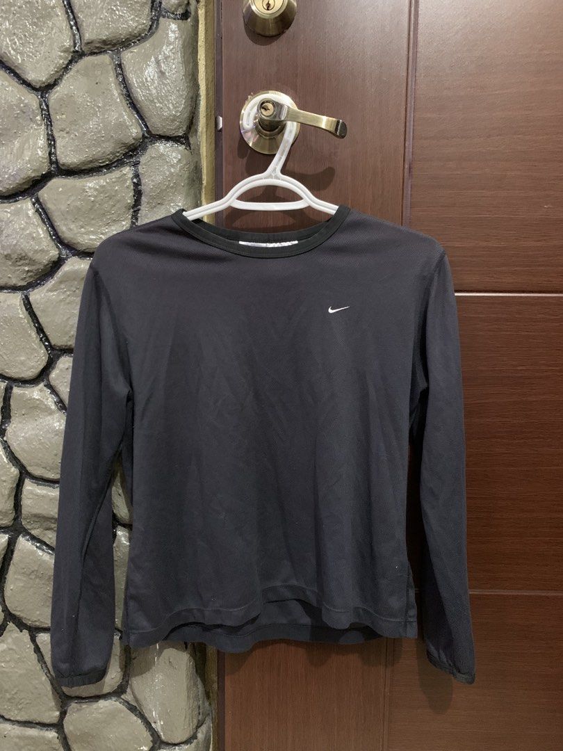 Nike Black Bluish Long Sleeve Shirt (Category: Tshirts & Polo Shirts ) located in Baguio. Submitted by thrifteditbaguio (Listing ID 1442665009, Image 1). Description: - Classic black long sleeve Nike shirt - Features iconic Nike swoosh logo on chest - Versatile for workouts or casual wear - Comfortable material - Ideal for layering.