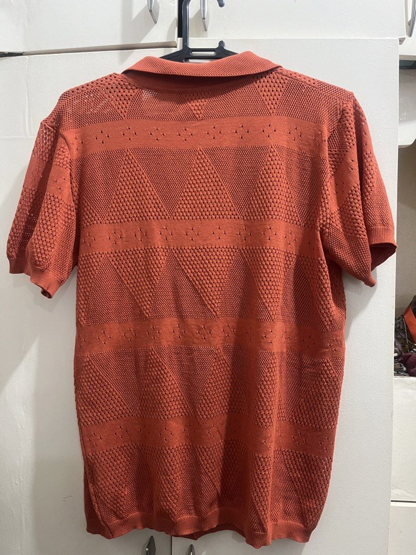 Orange Knitted Polo Shirt with Geometric Pattern (Category: Tshirts & Polo Shirts ) located in Cagayan de Oro. Submitted by everythingpreloved__ (Listing ID 1442686413, Image 2). Description: - Color: Burnt Orange - Style: Knitted Polo Shirt - Sleeve Length: Short Sleeves - Design: Geometric Pattern - Features: Button-up front, Collared neckline - Occasion: Casual or Smart-Casual - Styling: Easy to pair with various outfits.